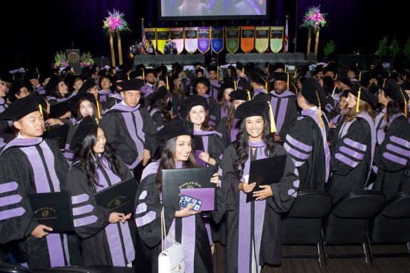 students sitting in their caps and gowns during commencement 2024