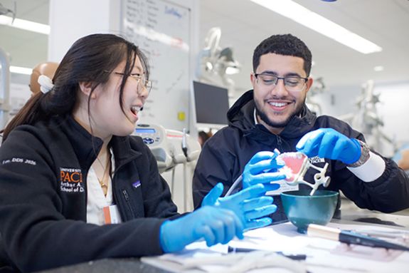female student instructor with male prospective student during hands-on demo in the simulation lab