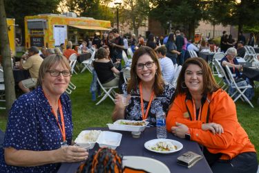 Three women smiling while having lunch