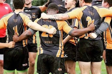Rugby players hugging on field