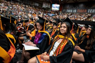 students dressed in commencement regalia