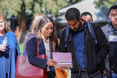 two people over look information on a piece of paper. 