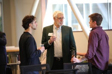 three men conversing with each other 