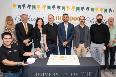 picture from the $1 million saved event of faculty, staff, students, president, provost, with a celebratory cake