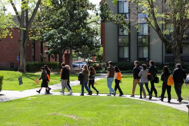 Group of people touring a campus. 
