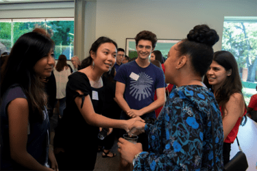 Students and alumni shake hands