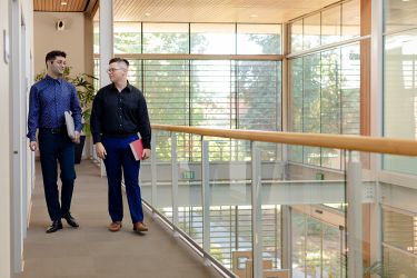 Two students walk together in a library