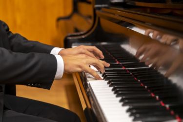 Student's hands on a piano keyboard