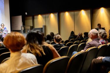 An audience listens to a presentation