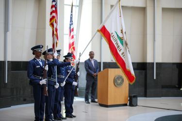 Members of the armed forces raising the California flag.