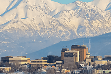 A photo of a city surrounded by snow covered mountains.