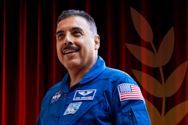 An image of Jose Hernandez in front of a dark red background 