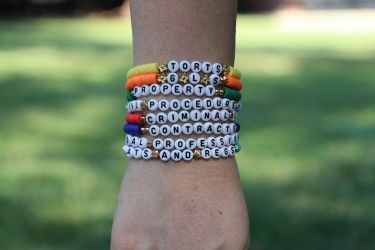 Layers of bracelets stacked on a person's arm. 