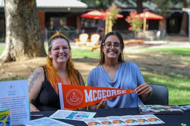 Two students hold up a McGeorge Pendant. 