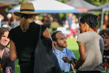 A group of people talk and smile.