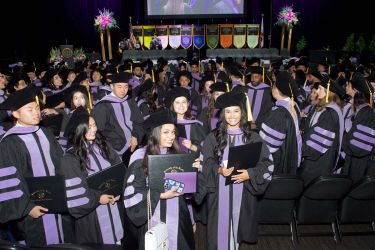 students sitting in their caps and gowns during commencement 2024