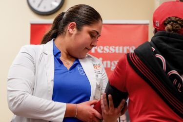 Student with patient at health care clinic