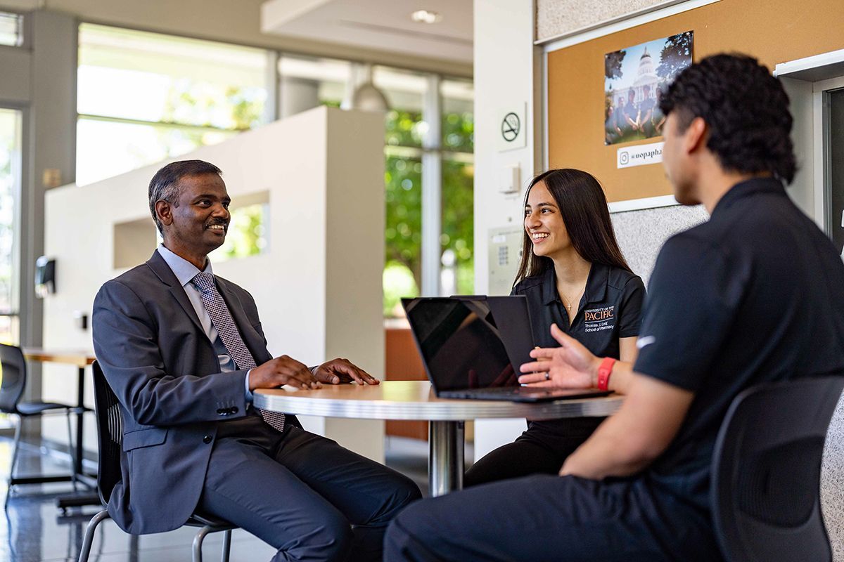 Two students and a faculty member having a conversation