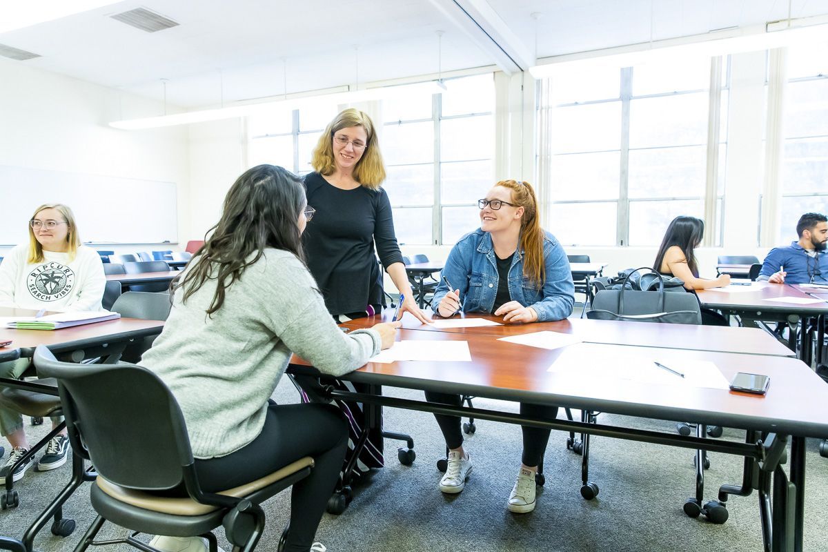 students interact with professor in classroom