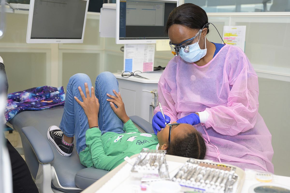 dental hygiene student with child patient