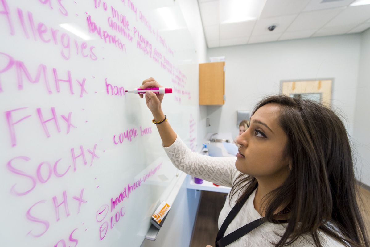 a student writes on a white board
