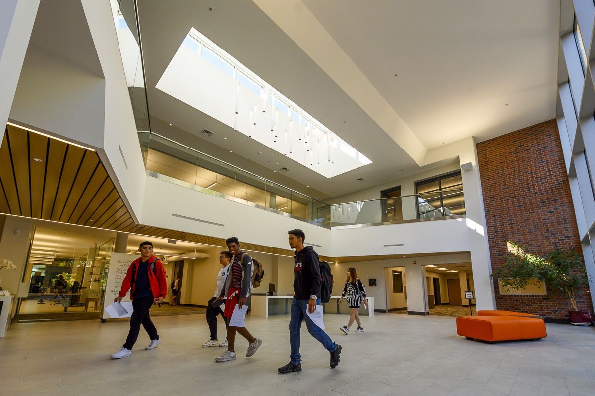 students walk in the lobby of the library