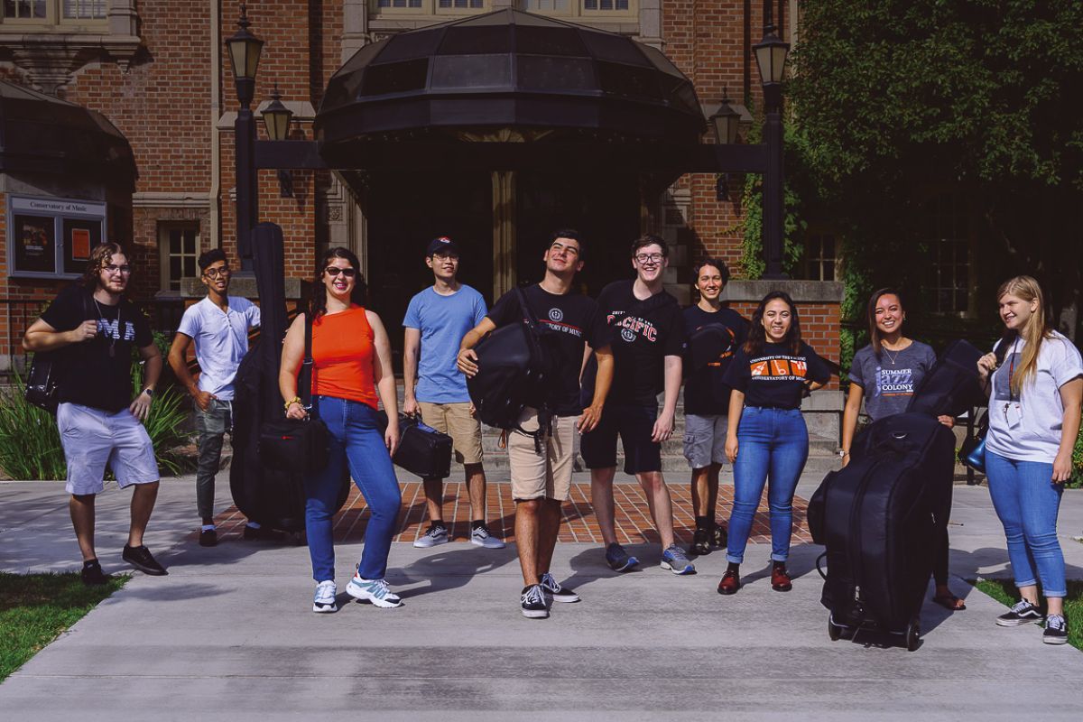 music students standing in front of Faye Spanos Concert hall