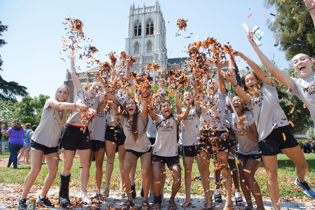 large group of students throwing confetti outside