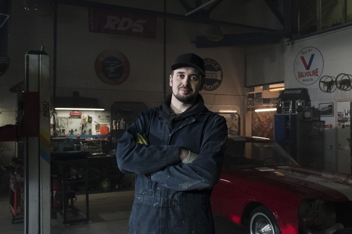 man standing in mechanic garage