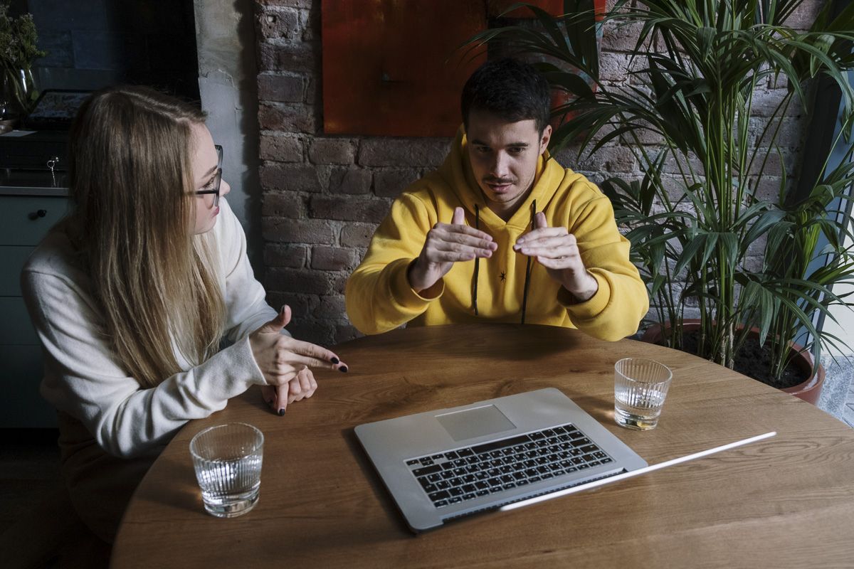 man signing while sitting at table