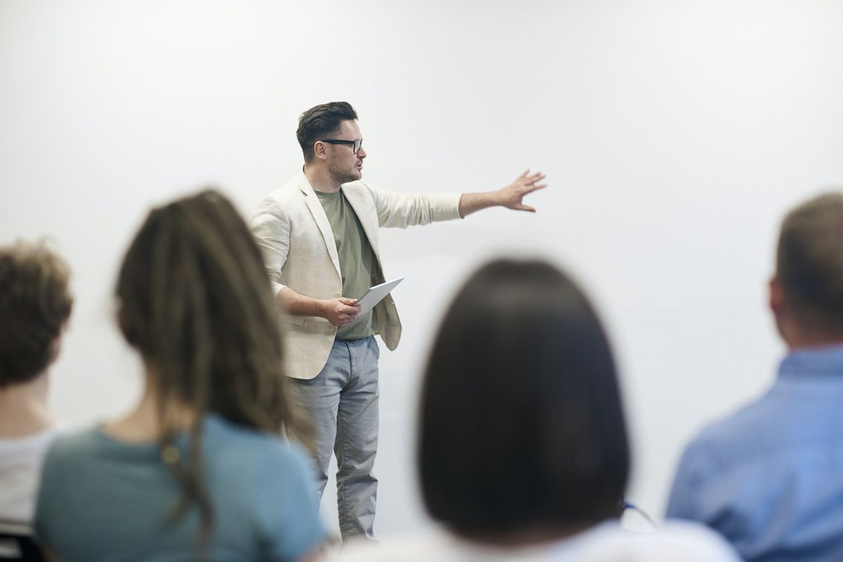 man leading meeting in front of coworkers