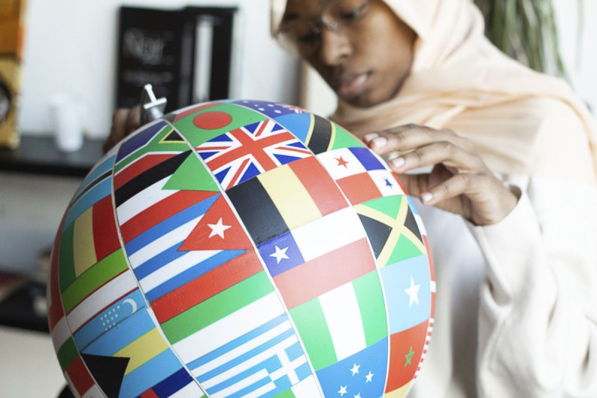 woman holding globe with flags