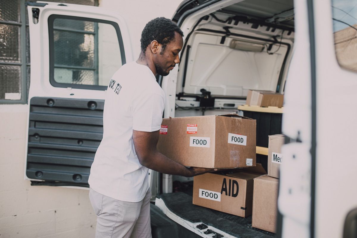 man loading food donations into vehicle