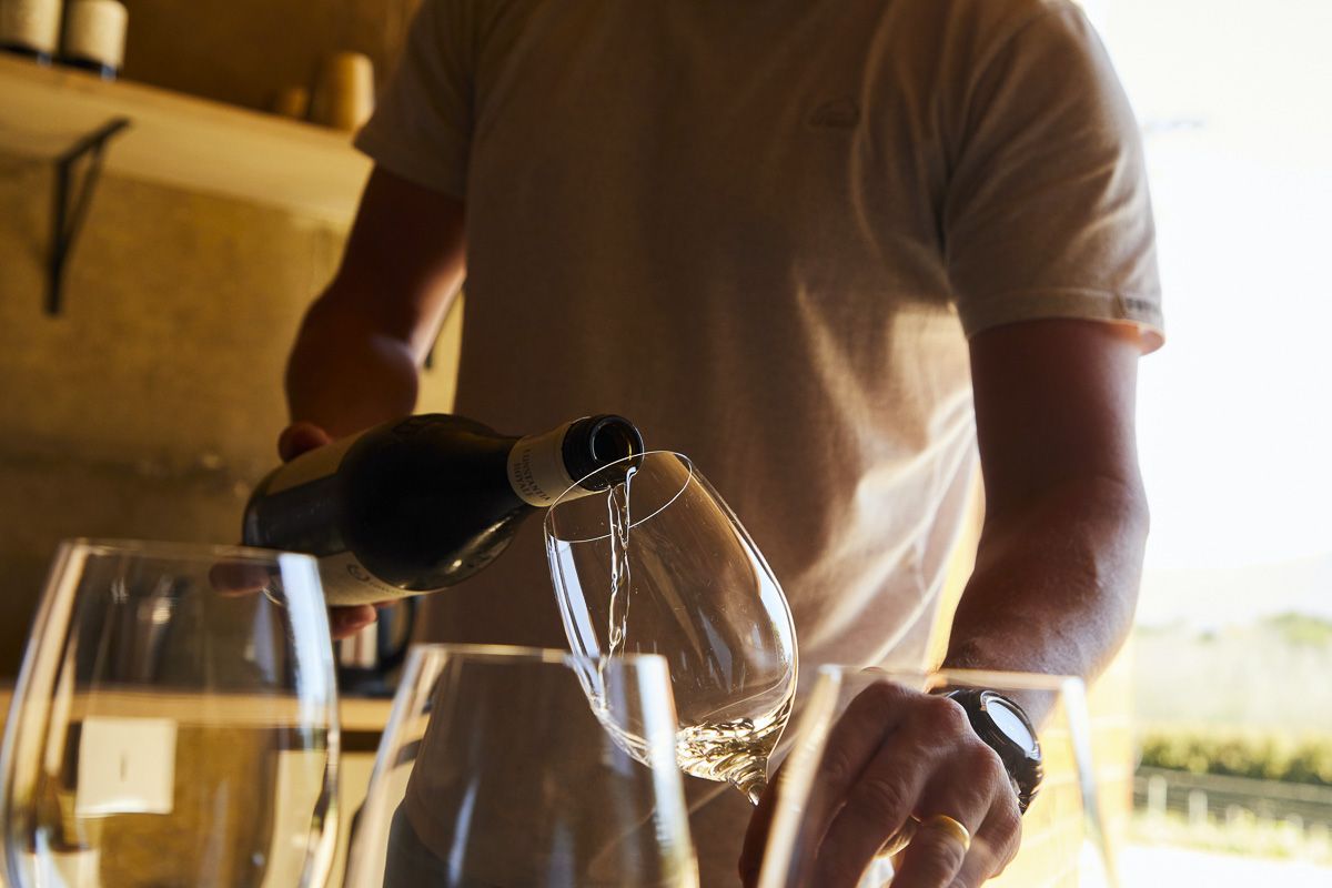 man pouring wine in glass