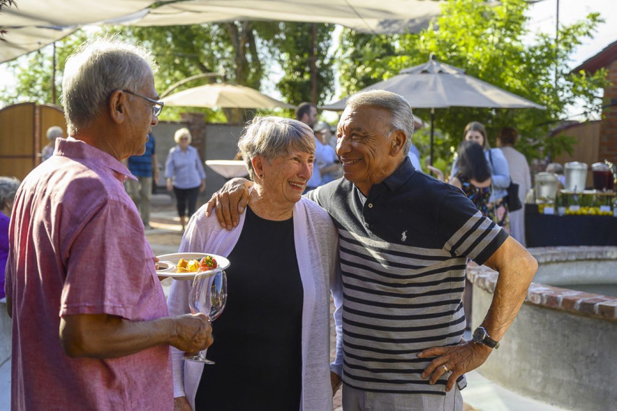 three OLLI members talk at a winery