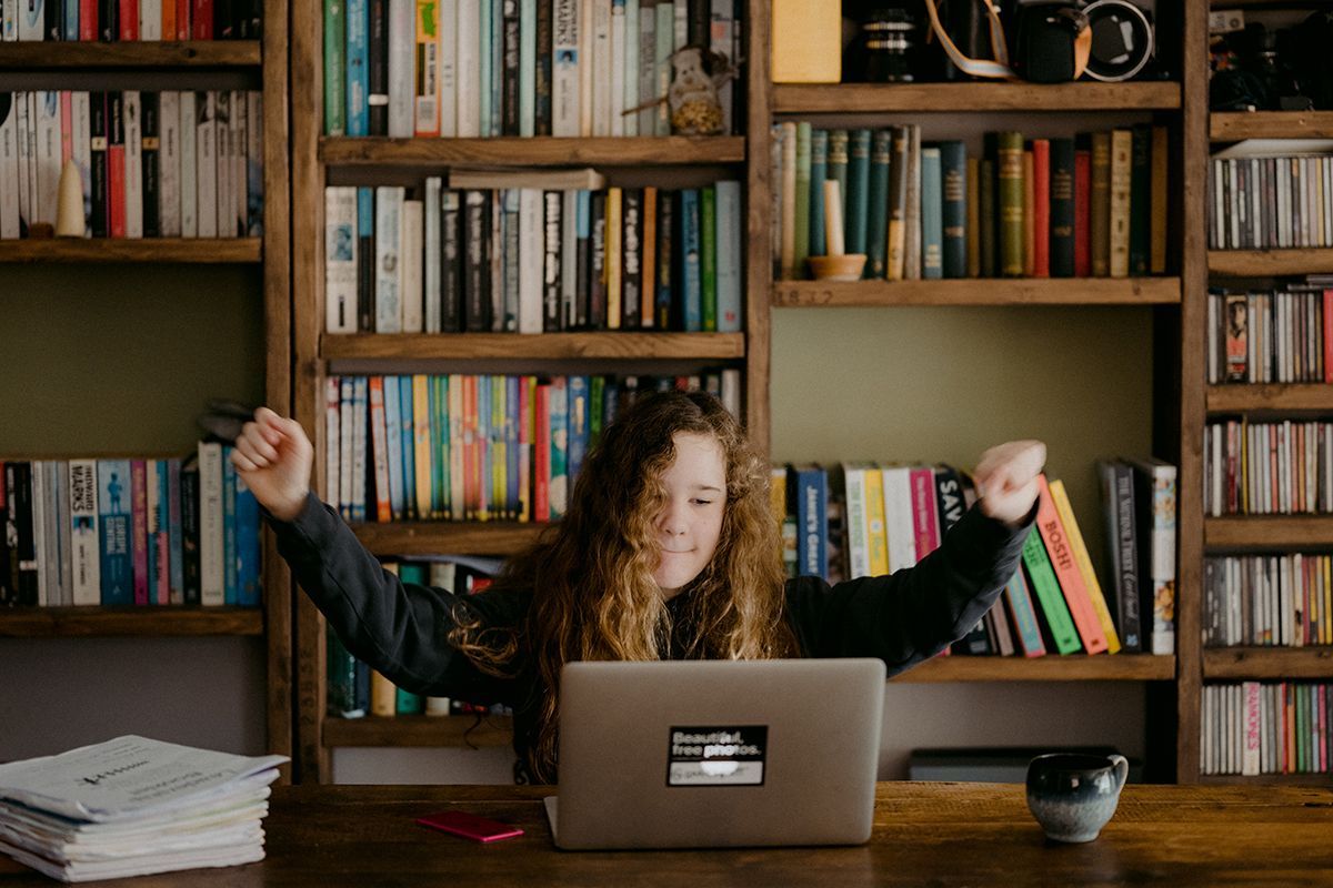 student in front of laptop in library area