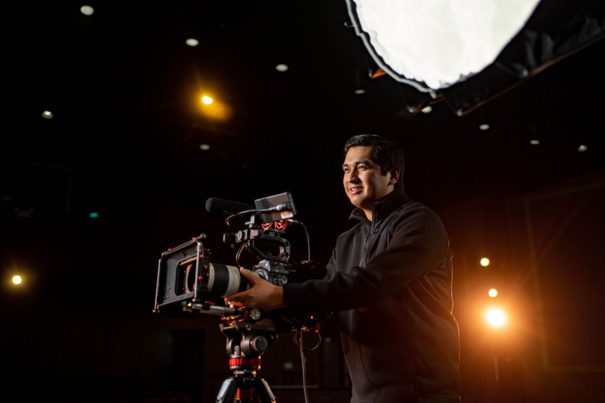 Media X major student behind a film camera