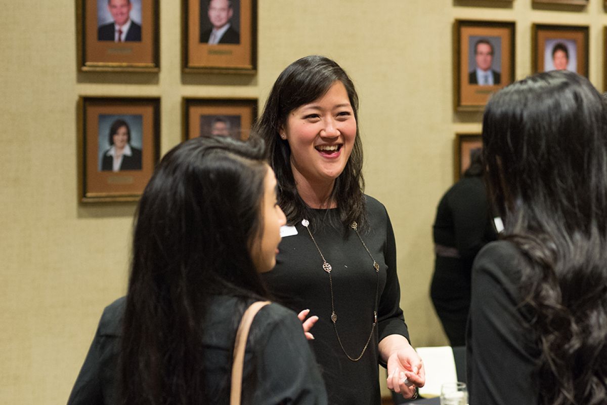Alumni board member speaks with students at an event.