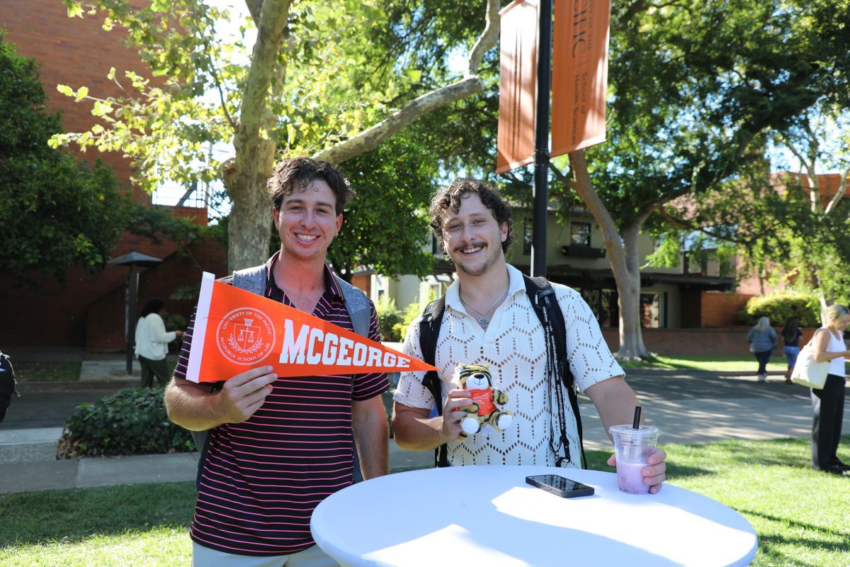 two students holding a sign that says McGeorge