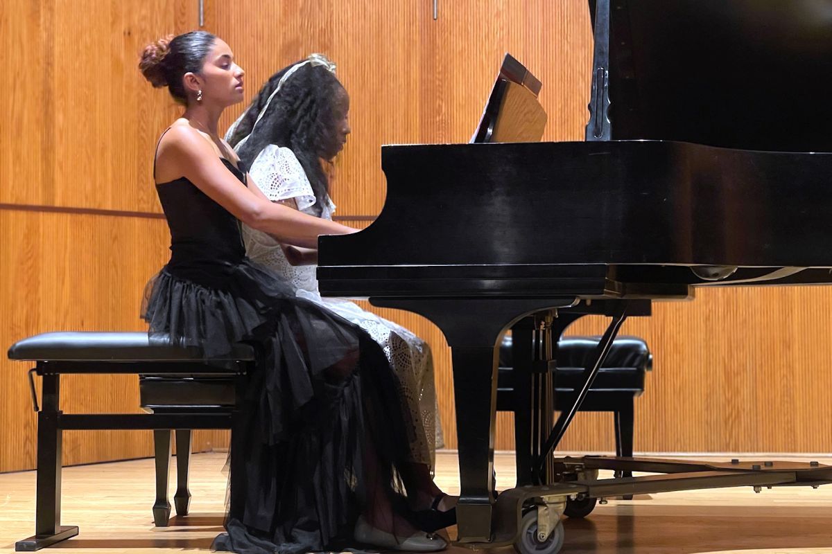 Two students playing the piano