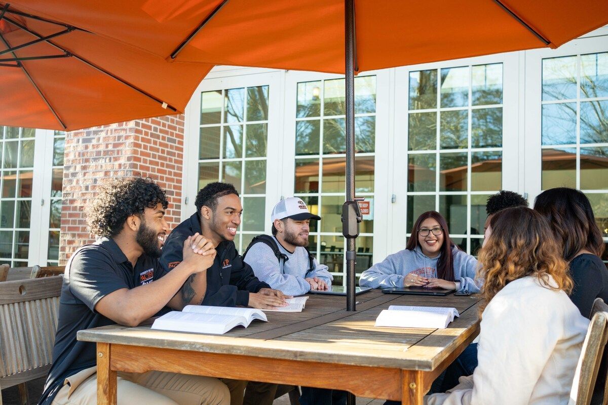 a group of CIP students sit together at an outdoor table