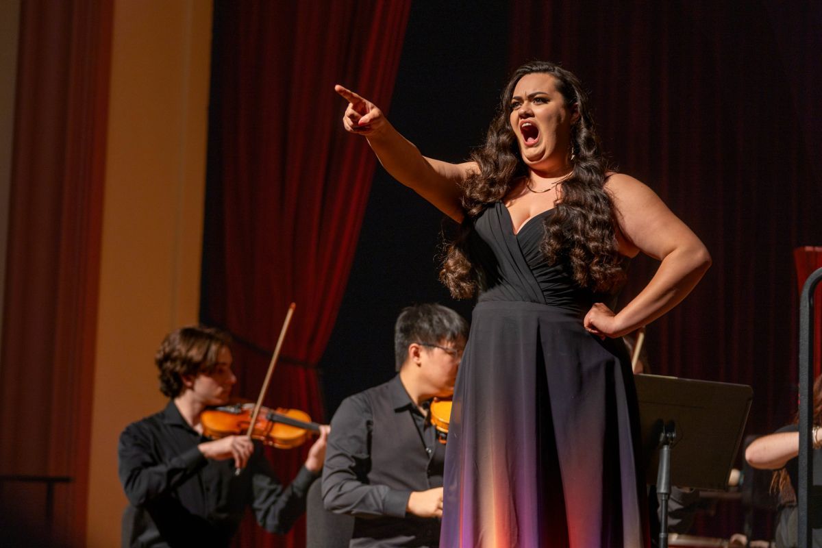 Senior music performance major sings on stage with an orchestra