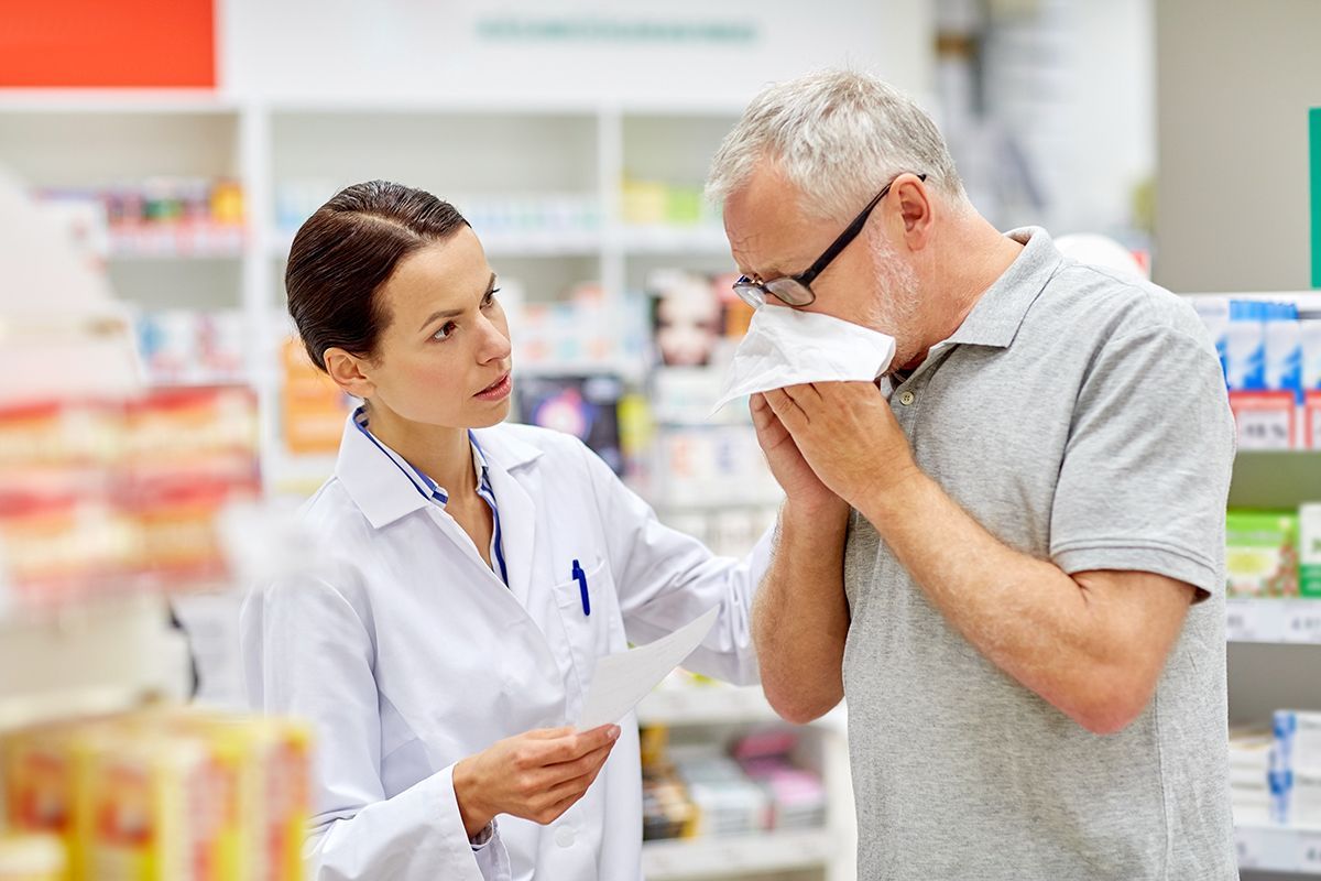 Close up shot of a patient interacting with a pharmacist at the counter