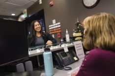 Staff talking over a desk and smiling. 