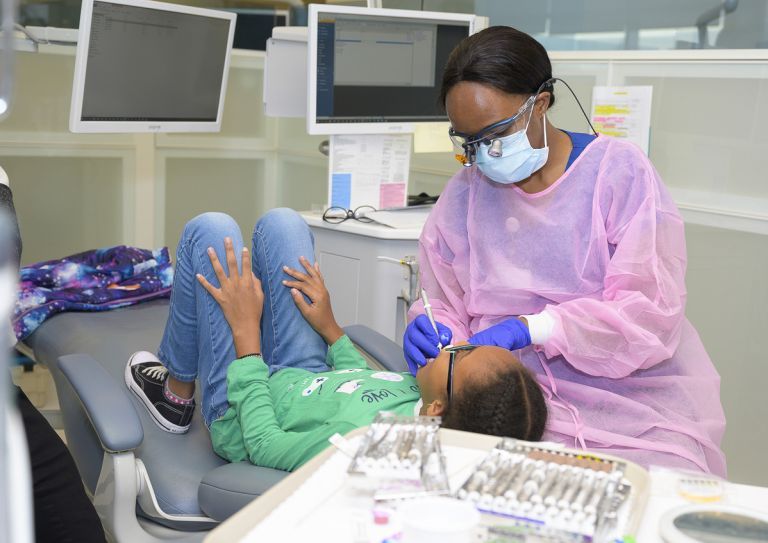 dental hygiene student with child patient