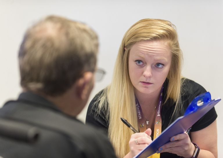 students taking notes on clipboard with patient