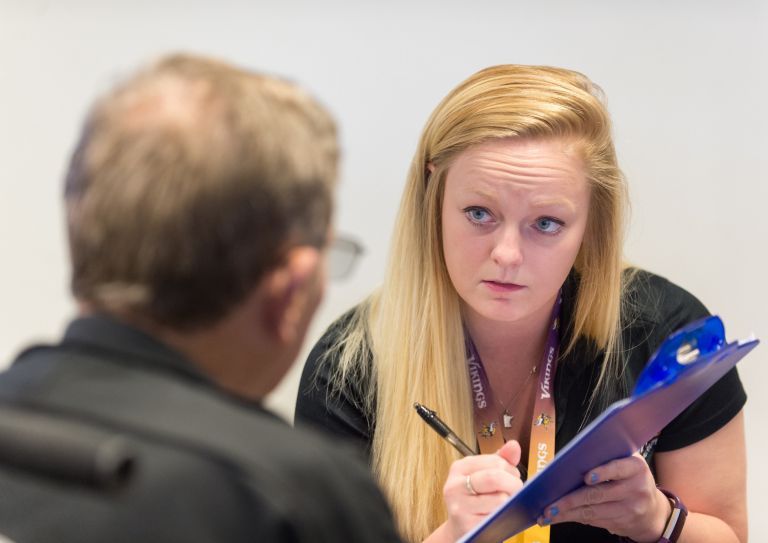 students taking notes on clipboard with patient