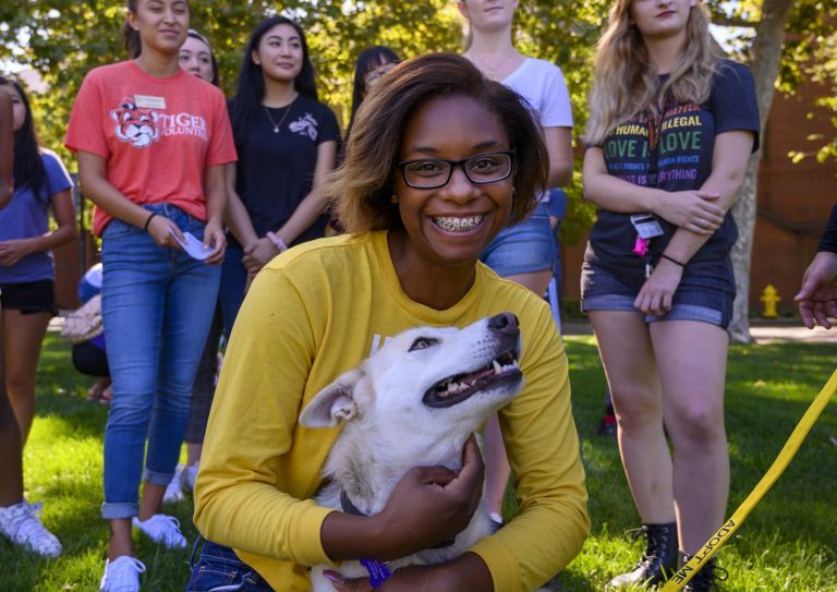 girl wrapping arms around dog