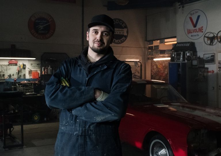 man standing in mechanic garage