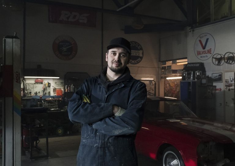 man standing in mechanic garage
